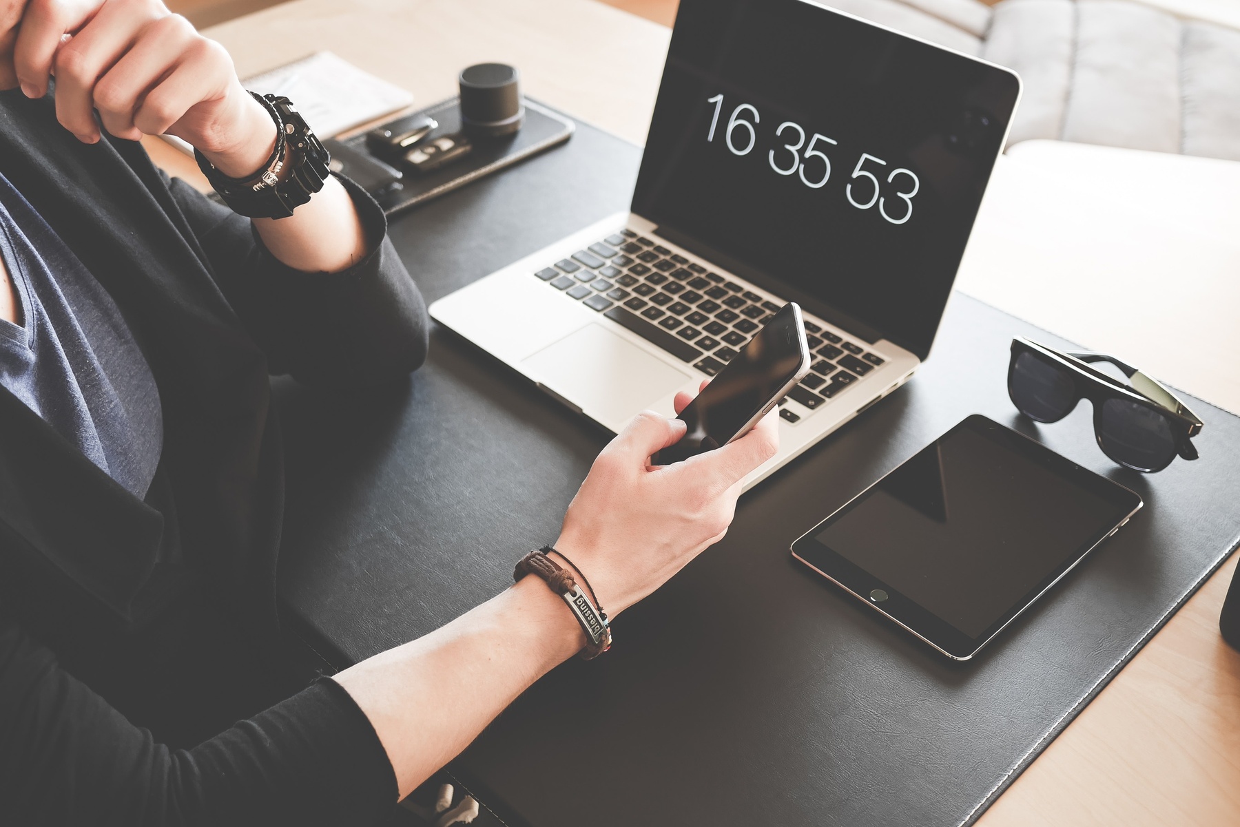 Woman using a smartphone while fronting a macbook pro and 196656